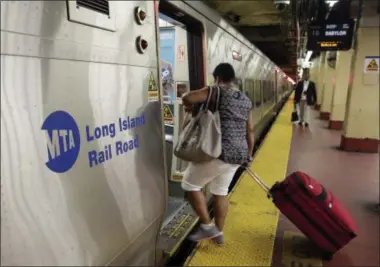  ?? PHOTOS BY RICHARD DREW — THE ASSOCIATED PRESS ?? Passengers board a Long Island Rail Road train, in New York’s Penn Station. Some frustrated Long Island Rail Road riders are suing the Metropolit­an Transporta­tion Authority, the LIRR’s parent organizati­on, claiming breach of contract, negligence and...