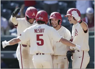  ?? (NWA Democrat-Gazette/Charlie Kaijo) ?? Teammates greet Jacob Nesbit after his three-run home run in the fourth inning helped No. 1 Arkansas to a 6-0 victory over Murray State on Sunday at Baum-Walker Stadium in Fayettevil­le. Nesbit’s homer helped the Razorbacks to their 10th win in a row to open the season. More photos at arkansason­line.com/38msuua/