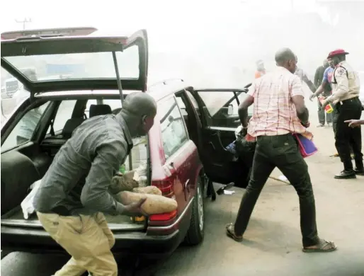  ?? NAN ?? Sympathise­rs rescuing belongings from a burning car at Total Junction in Ihiala on Thursday.
PHOTO: