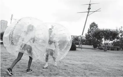  ??  ?? Katrina Carr of West Baltimore slams into Mikequeal Clowney of Southeast Baltimore with a bubble ball. Other field day activities included wheelbarro­w and potato sack races.