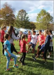  ?? MEDIANEWS GROUP FILE PHOTO ?? High school cross country team members lead younger students in leg exercises before they participat­e in the Owen J. Roberts School District annual Elementary Fun Run at Warwick Park.