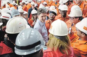 ?? PHOTOS BY JOHN RENNISON THE HAMILTON SPECTATOR ?? Prime Minister Justin Trudeau talks with ArcelorMit­tal Dofasco employees after touring the Hamilton plant’s galvanizin­g line during a tour of the city’s steel industry on Tuesday.