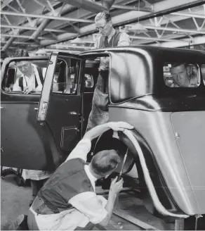  ??  ?? Men work on the body of a car at the Triumph Works, Coventry, in 1933