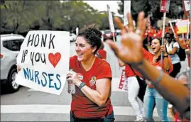  ?? JOSE M. OSORIO/CHICAGO TRIBUNE ?? Betsy Overland holds a sign Sept. 20 as vehicles drive by as she and other registered nurses rally near the University of Chicago Medical Center, where nurses held a strike.