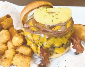  ??  ?? Cajun tots, a deep-fried sweet potato pie and an Evan ‘The Show Stopper’ burger, featuring two Angus beef patties, bacon, pineapple, grilled red onion, mayo and sharp cheddar on a brioche bun.