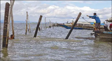  ?? JOVEN CAGANDE ?? Members of a government task force led by the DENR dismantle fish pens in Laguna de Bay yesterday.