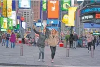 ?? AP PHOTO/SETH WENIG ?? Pedestrian­s pose for pictures in Times Square on Nov. 15 in New York.