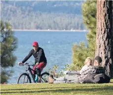  ?? RICH PEDRONCELL­I/AP 2017 ?? About 67% of Lake Tahoe’s households make less money than needed for housing and living expenses. Above, a bicyclist in South Lake Tahoe, California.