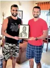  ??  ?? Dimuth Karunaratn­e poses with his portrait alongside Anuranga Wijepala