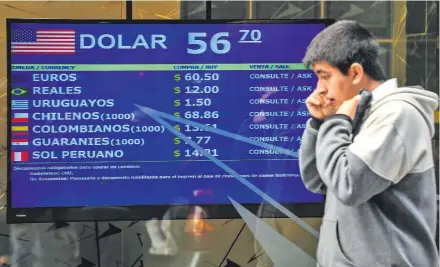  ??  ?? Inició en Argentina una serie de controles cambiarios, pero el gobierno anunció que no habrá límites de retiro de dinero de los bancos, buscando espantar el fantasma del “corralito” que bloqueó el dinero de los ahorristas en el año 2001. (AFP)