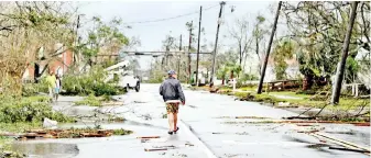  ??  ?? A man walks down the street after Hurricane Michael made landfall in Panama City, Florida.