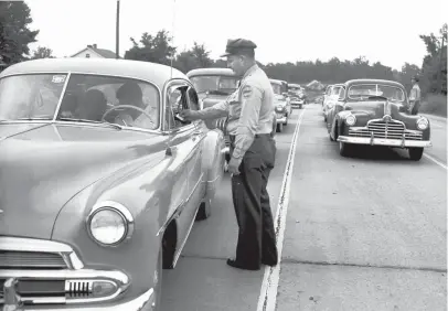  ?? THE COMMERCIAL APPEAL ?? Corp. H.F. Mcclaren, left, and Lt. W.D. Crowe of the Tennessee Highway Patrol check for expired driver’s licenses at a roadblock on U.S. 51 near Frayser on July 14, 1951.