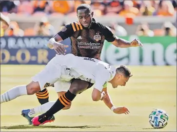 ?? Michael Wyke Associated Press ?? JAVIER “CHICHARITO” HERNÁNDEZ, falling against Houston Dynamo defender Maynor Figueroa last February, lost his grandfathe­r and, during the pandemic, his wife and two children moved to Australia.