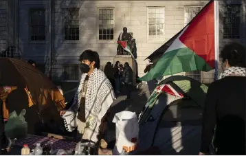  ?? BEN CURTIS — THE ASSOCIATED PRESS ?? A student protester is draped in the Palestinia­n flag at an encampment of students protesting against the war in Gaza at Harvard University in Cambridge, Mass., on Thursday.