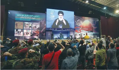  ?? ?? HEZBOLLAH LEADER Hassan Nasrallah addresses his supporters via a screen during a rally on Friday marking Quds Day, in Beirut’s southern suburbs.