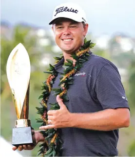  ??  ?? Patton Kizzire holds the Sony Open golf tournament trophy Photo: AP