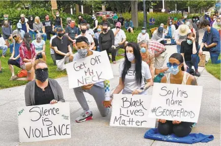  ?? AMY DAVIS/BALTIMORE SUN ?? Amber Poe, from left, Tyje Ross, Tara Thompson and Taylor Saffold “take a knee for justice” Sunday near the old Towson Courthouse.