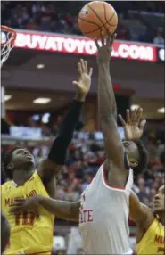  ?? JAY LAPRETE — THE ASSOCIATED PRESS ?? Ohio State’s Jae’Sean Tate, center, shoots between Maryland’s Darryl Morsell, left, and Joshua Tomaic during the second half on Jan. 11 in Columbus.