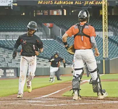  ?? KENNETH K. LAM/BALTIMORE SUN PHOTOS ?? Towson’s Tariq Talley, from left, and Tuscarora’s Kyle Sanger score for the North team in the fourth inning of the 40th annual Brooks Robinson Senior All-Star game at Oriole Park at Camden Yards on Sunday.