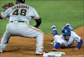  ?? ROBERT GAUTHIER/TRIBUNE NEWS SERVICE ?? The Dodgers' Mookie Betts slides back on a pickoff attempt by Giants pitcher Drew Smyly in the fifth inning in Los Angeles on Thursday.