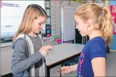  ?? TERRENCE MCEACHERN/THE GUARDIAN ?? Nora Cunniffe, left, and Eve Morris, both 10, square off for a game of rock, paper, scissors during the Hour of Code event.