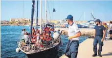  ?? FOTO: DPA ?? Seenotrett­er bringen Migranten in den Hafen von Lampedusa: Was in einem solchen Fall passiert, ist unter den EU- Staaten jedes Mal erneut Verhandlun­gssache.
