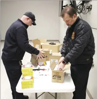  ?? Brodie Johnson • Times-Herald ?? Forrest City Fire Marshal Jeremy Sharp, left, and Fire Chief Shane Dallas open boxes of smoke alarms to be placed on their trucks for installati­on. The FCFD will install smoke alarms free of charge in any home within the Forrest City city limits.