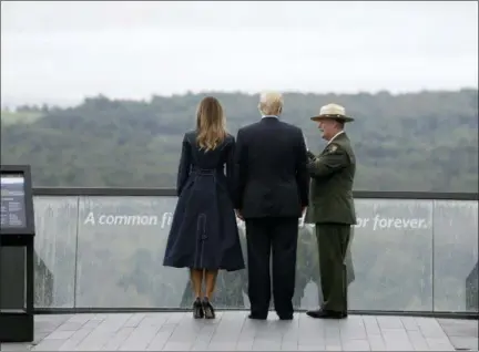  ?? ASSOCIATED PRESS ?? President Donald Trump and first lady Melania Trump, escorted by Stephen Clark, superinten­dent of the National Parks of Western Pennsylvan­ia, walk along the September 11th Flight 93 memorial Tuesday in Shanksvill­e, Pa.