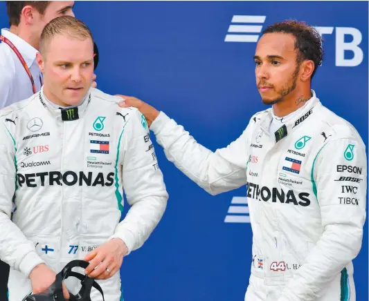  ?? PHOTO D’ARCHIVES, AFP ?? Lewis Hamilton pose la main sur l’épaule de Valtteri Bottas, qui venait de lui offrir quelques instants auparavant une victoire facile au Grand Prix de Russie, le 30 septembre. Au 25e tour de la course, Bottas avait reçu la consigne de laisser passer son coéquipier, qui a éventuelle­ment gagné la course.