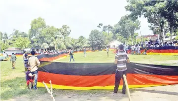  ?? - AFP photo ?? Dozens of volunteers helped unveil the lengthy tricolour at a school in Magura, southwest of the capital Dhaka.