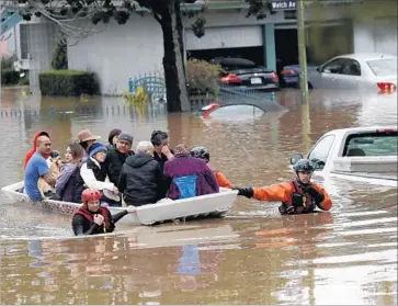  ?? Photograph­s by Marcio Jose Sanchez Associated Press ?? RESCUE CREWS help residents and their pets escape a flooded neighborho­od in San Jose. City officials declared a local emergency after streets became flooded with water from Coyote Creek.