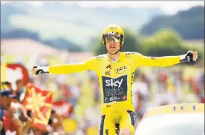  ?? Christophe Ena / Associated Press ?? Britain’s Geraint Thomas, wearing the overall leader’s yellow jersey, reacts as he crosses the finish line during the 20th stage of the Tour de France on Saturday.