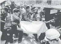  ?? — Gambar Bernama ?? OPERASI MENCARI: Anggota bomba dan penyelamat mengusung mayat yang terperangk­ap dalam kejadian tanah runtuh.