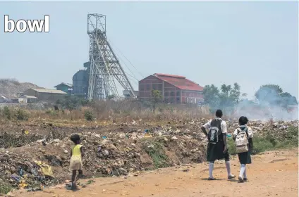  ?? Picture: Bloomberg ?? MINING’S LEGACY. Tomorrow’s leaders walk past yesterday’s smoulderin­g industrial garbage. The toxic legacy of South African mining may be an unaffordab­le burden for future generation­s.