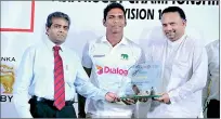  ??  ?? Sri Lanka rugby skipper Fazil Marija (centre) presenting the ARFU A5N Division I Trophy to the Minister of Sports Navin Dissanayak­e (R) and Dr. Hans Wijesuriya, the Chief Executive Officer of Dialog Axiata (L) – Pix by Amila Gamage