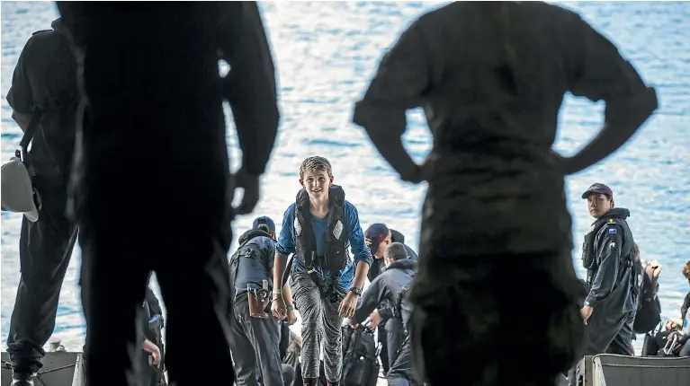  ?? PHOTOS: BRADEN FASTIER/NELSON MAIL ?? One of the more than 150 volunteers who acted as internally displaced people for the Southern Katipo exercise enters the HMNZS Canterbury in Shakespear­e Bay in the Marlboroug­h Sounds.