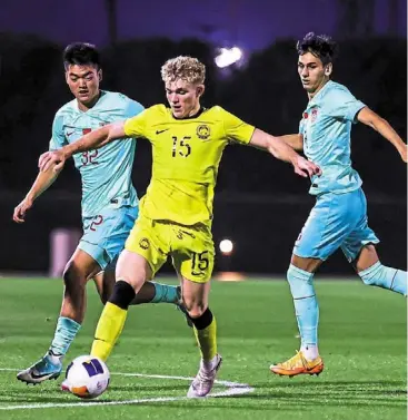  ?? — FAM ?? Standing out: Fergus tierney (in yellow) in action against China during their closed door friendly in doha.