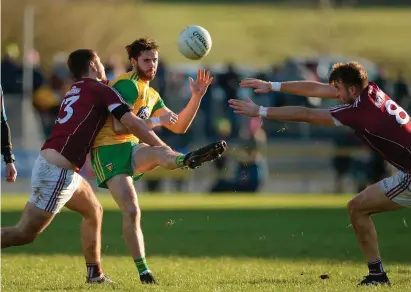  ?? OLIVER McVEIGH/SPORTSFILE ?? Donegal’s Odhran Mac Niallais gets the ball away under pressure from Galway duo Patrick Sweeney and Paul Conroy during their defeat in O’Donnell Park in this Allianz NFL Division One clash