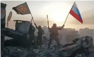  ?? Photo: Reuters ?? Wagner mercenarie­s wave flags on top of a building in a video released along with a statement claiming to have taken Bakhmut.
