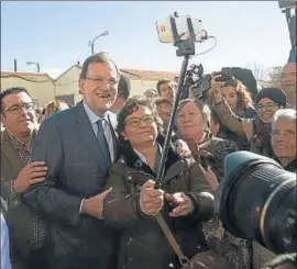  ?? SANTIAGO TORRALBA / EFE ?? Rajoy fotografiá­ndose con vecinos de Las Mesas, un pueblo de Cuenca