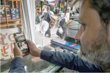  ?? — AFP photo ?? A man uses the social media platform X on his phone at a market in Islamabad, Pakistan.
