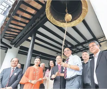  ?? — Photo by Chimon Upon ?? Abdul Karim (third right) rings the bell to officially launch the Marian Boutique Lodging House. Bolly is at fourth right, Zuraini (fifth right) and Rosemarie (sixth right).
