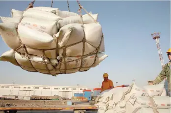  ?? — Reuters ?? Workers transport imported soybean products at a port in Nantong, Jiangsu province, China .