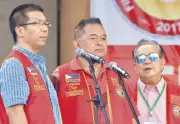  ??  ?? Rene Yan, Loosin Yap and Filipino-Chino Friendly Foundation, Inc. program and gift-giving project coordinato­r Albino Li Sy lead the singing of the Chinese national anthem