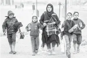  ?? — Gambar AFP ?? MENYELAMAT­KAN DIRI: Seorang wanita berjalan kaki bersama anak-anaknya selepas melarikan diri daripada pengeboman di kawasan hospital Al-Shifa ketika mereka tiba di kem pelarian Nuseirat di tengah Semenanjun­g Gaza kelmarin.