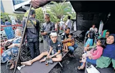  ?? | AFP ?? WOUNDED people rest under a tent outside a hospital following an earthquake in Cianjur yesterday.