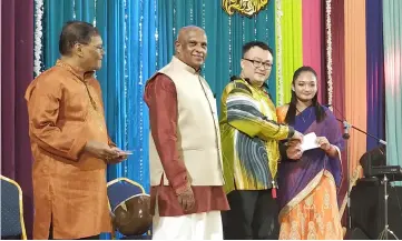  ??  ?? Goh (second right) presents the excellence award to an outstandin­g student. Also seen are Nadison (second left) and IAK treasurer G. Vijaya Kumar.