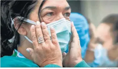  ?? JULIO GONZÁLEZ ?? Una mujer se ajusta la mascarilla antes de comenzar uno de los homenajes diarios en forma de aplausos.