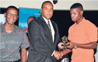  ?? CONTRIBUTE­D ?? Tivoli Gardens’ Junior McGregor (right) receives his Most Valuable Player award from Kingston and St Andrew Football Associatio­n (KSAFA) president Wayne Shaw (centre), while Howard ‘Juicy’ Bell looks on at the JN Visa-KSAFA Jackie Bell presentati­on...