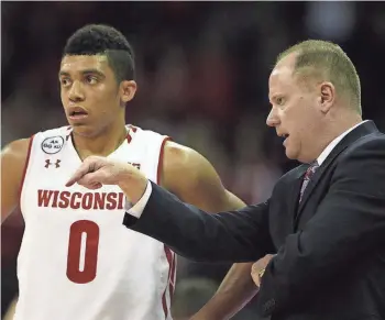  ?? MARY LANGENFELD / USA TODAY SPORTS ?? UW head coach Greg Gard talks with reserve guard D'Mitrik Trice, who averages about 18 minutes a game.